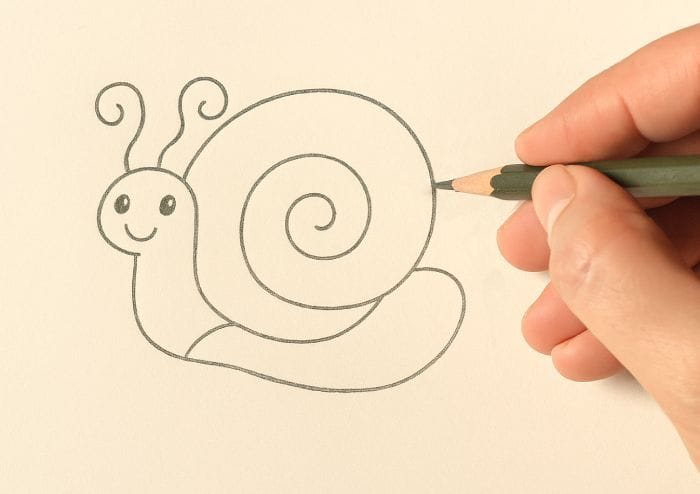 Hand drawing a cute cartoon snail with a spiral shell using a pencil on white paper.