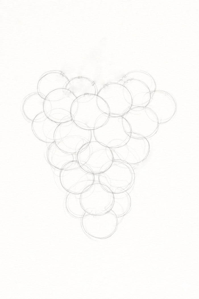Light pencil sketch showing a rough circle layout used to plan the shape of a bunch of grapes