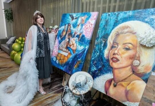 Art exhibition display featuring surreal and classic portrait oil paintings on easels by artist Andrea Castañeda