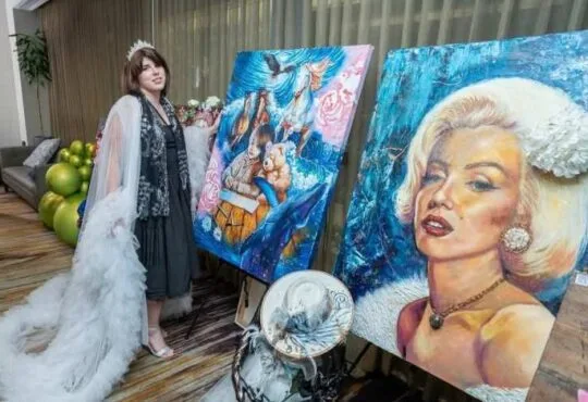 Art exhibition display featuring surreal and classic portrait oil paintings on easels by artist Andrea Castañeda