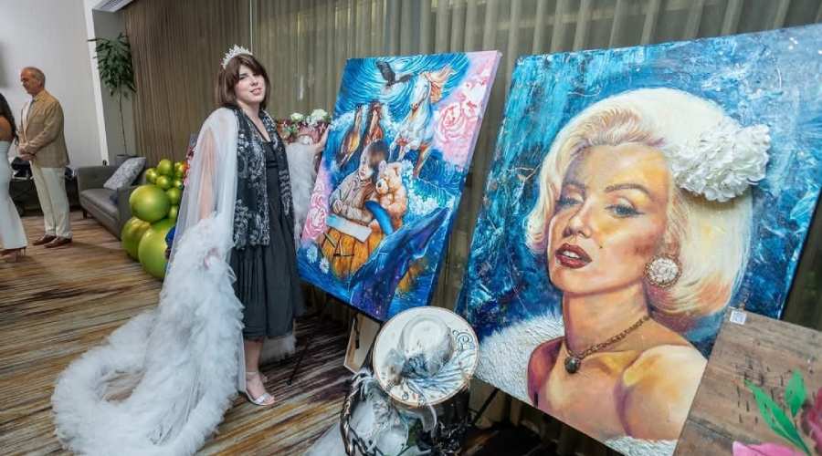 Art exhibition display featuring surreal and classic portrait oil paintings on easels by artist Andrea Castañeda