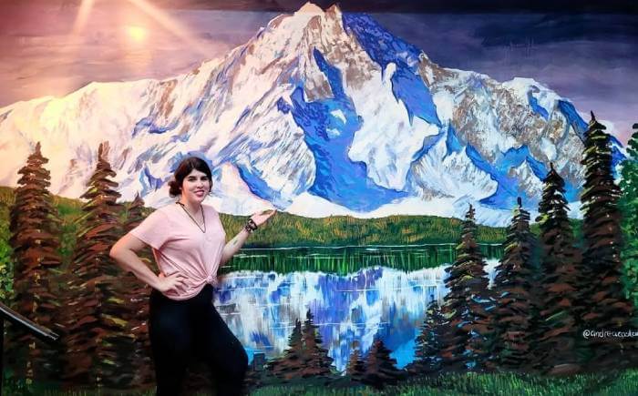 Snow mountain and lake mural painting with trees and reflection, created by artist Andrea Castañeda