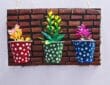 Colorful artificial flowers placed inside decorated paper cups mounted on a cardboard wall decor base, completing the DIY project