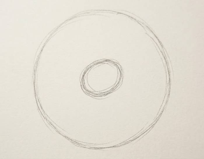 Pencil sketch showing a large outer circle with a smaller inner circle in the center, illustrating the second step of a peony flower drawing tutorial.