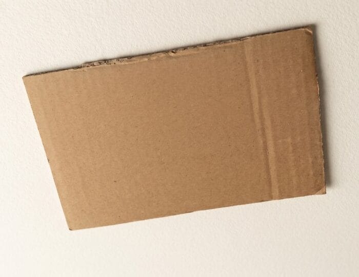 Rectangular piece of waste cardboard used as base for DIY wall decor project