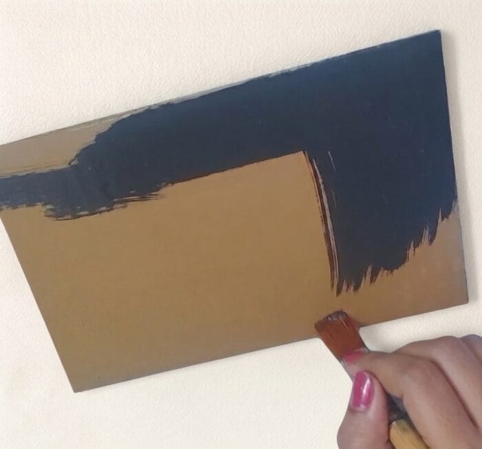 Hand painting black color on cardboard base for DIY wall decor background step 2